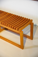 Banco Sucello com estrutura em madeira maciça de Jequitibá, 160 cm de largura, ideal para salas, varandas cobertas e espaços internos. Design minimalista e acabamento na cor Mel, perfeito para diversos estilos de decoração.