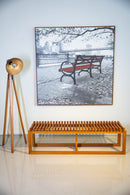 Banco Sucello com estrutura em madeira maciça de Jequitibá, 160 cm de largura, ideal para salas, varandas cobertas e espaços internos. Design minimalista e acabamento na cor Mel, perfeito para diversos estilos de decoração.