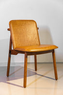 Cadeira Guanabara, design sofisticado com assento e encosto em couro de alta qualidade e estrutura em madeira maciça castanho. Sem braços e ideal para ambientes elegantes como salas de jantar e escritórios. Acompanha uma unidade.