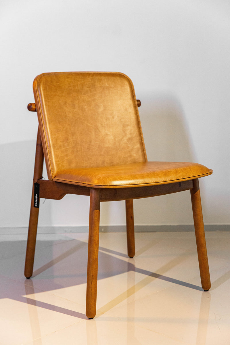 Cadeira Guanabara, design sofisticado com assento e encosto em couro de alta qualidade e estrutura em madeira maciça castanho. Sem braços e ideal para ambientes elegantes como salas de jantar e escritórios. Acompanha uma unidade.