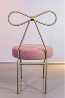 Cadeira Lace em aço carbono, com encosto em formato de laço, assento estofado em tecido nas cores rosa e taupe. Design elegante e confortável, ideal para salas de jantar e home office. Acompanha uma unidade.