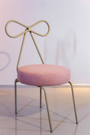Cadeira Lace em aço carbono, com encosto em formato de laço, assento estofado em tecido nas cores rosa e taupe. Design elegante e confortável, ideal para salas de jantar e home office. Acompanha uma unidade.