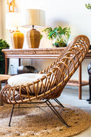 Poltrona Lotus feita de vime natural com acabamento em verniz fosco e detalhes em espiral. Design sofisticado e exclusivo, ideal para ambientes de alto padrão. Dimensões: 90 cm (A) x 90 cm (L) x 95 cm (P). Produto entregue montado. Outros itens mostrados na fotografia não estão incluídos.