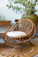 Poltrona Lotus feita de vime natural com acabamento em verniz fosco e detalhes em espiral. Design sofisticado e exclusivo, ideal para ambientes de alto padrão. Dimensões: 90 cm (A) x 90 cm (L) x 95 cm (P). Produto entregue montado. Outros itens mostrados na fotografia não estão incluídos.