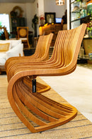 Poltrona Pantosh com design geométrico e escultural, inspirada na Cadeira Panton de Verner Panton e na Poltrona Willow de Charles Rennie Mackintosh. Estrutura em madeira maciça de alta qualidade, compensado multilaminado e acabamentos premium. Dimensões: 78 cm (A) x 66 cm (L) x 60 cm (P). Outros itens na fotografia não estão incluídos.