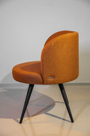 Poltrona Trila em tecido bouclé terracota, com estrutura de madeira maciça de eucalipto e acabamento em verniz PU. Ideal para compor ambientes sofisticados e versáteis. Dimensões: 84 cm (A) x 75 cm (L) x 72 cm (P). Outros itens na fotografia não estão incluídos.