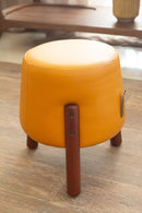 Puff redondo revestido em couro legítimo na cor laranja vibrante. Dimensões: 45 cm de altura e 42 cm de diâmetro. Ideal como assento extra, apoio ou peça decorativa. Outros itens na fotografia não estão incluídos.