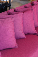 Sofá Ink Vinho com design contemporâneo e estrutura robusta, revestido em tecido de alta resistência. Dimensões: 85 cm (A) x 280 cm (L) x 85 cm (P). Ideal para salas de estar, escritórios e ambientes sofisticados. Outros itens na fotografia não estão incluídos.