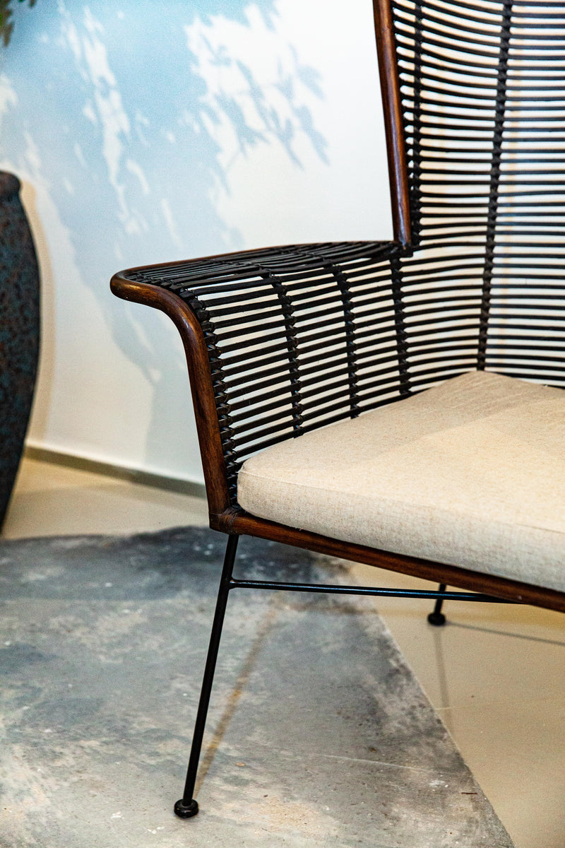 Sofá Manila feito à mão com estrutura em rattan natural, projetado para duas pessoas. Dimensões: 100 cm (A) x 120 cm (L) x 80 cm (P). Ideal para salas de estar, varandas ou áreas externas cobertas. Produto artesanal com variações de cor e textura. Outros itens na fotografia não estão incluídos.